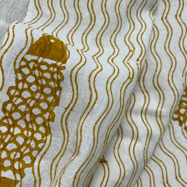 Close-up of fabric with gold fish and wavy line pattern