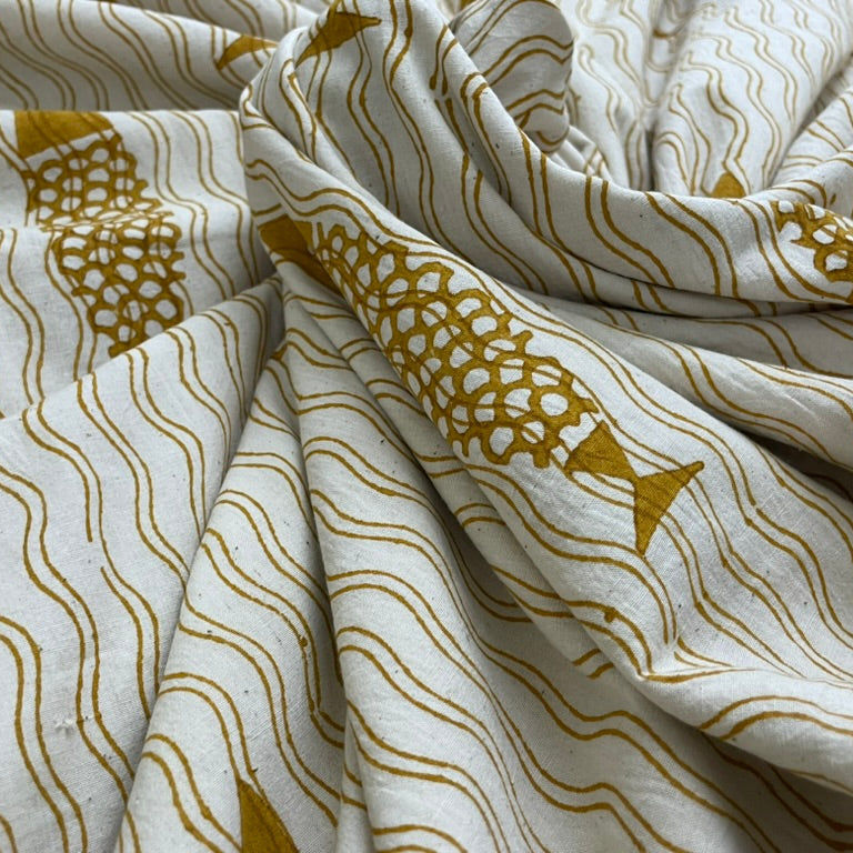 Fabric with gold fish and wave patterns on a white background