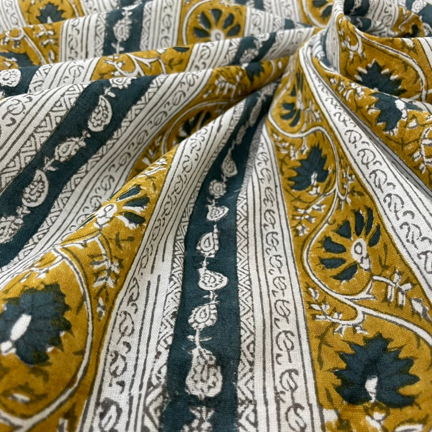 Close-up of patterned fabric with black, gold, and white design.