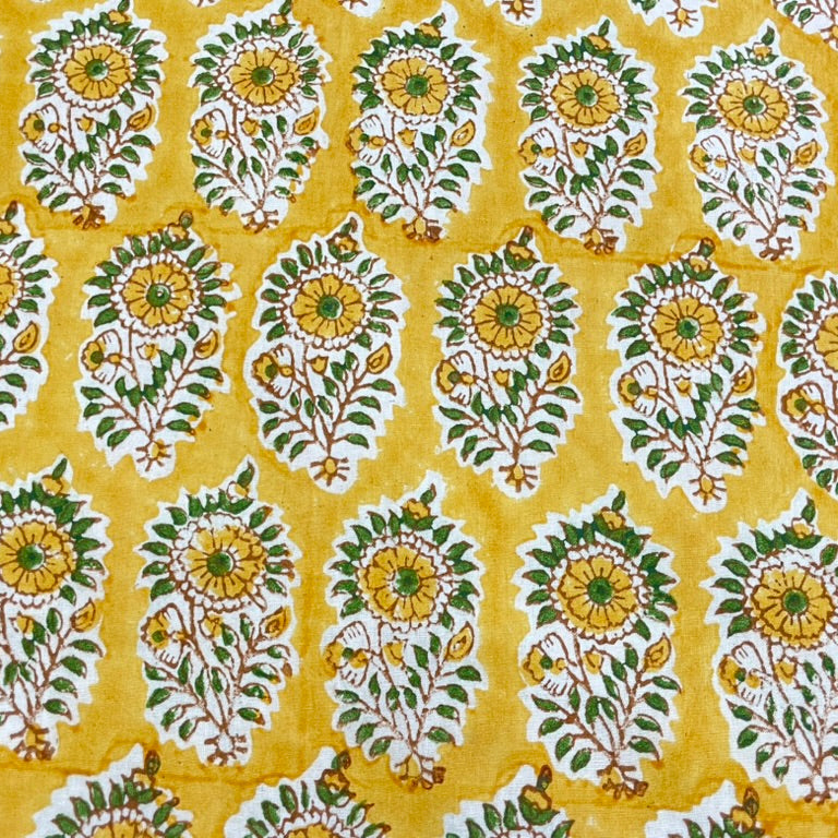 Patterned fabric with green and white floral design on a yellow background