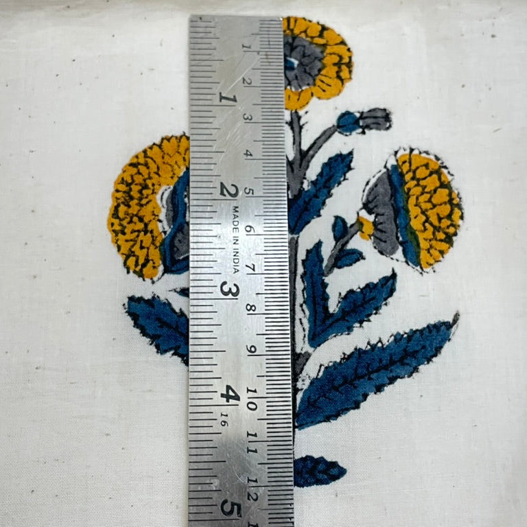 Embroidered floral design with a ruler for scale on a white background