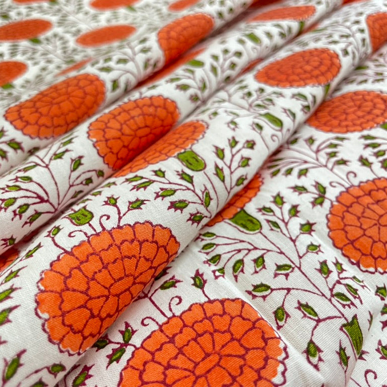 Fabric with orange floral pattern on a white background