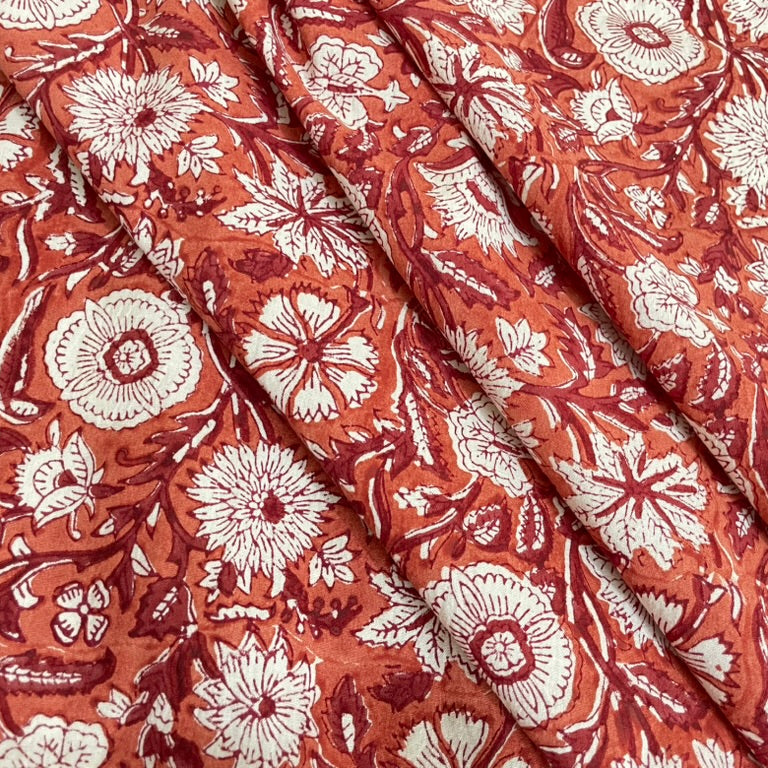 Floral patterned fabric with white flowers on a red-brown background