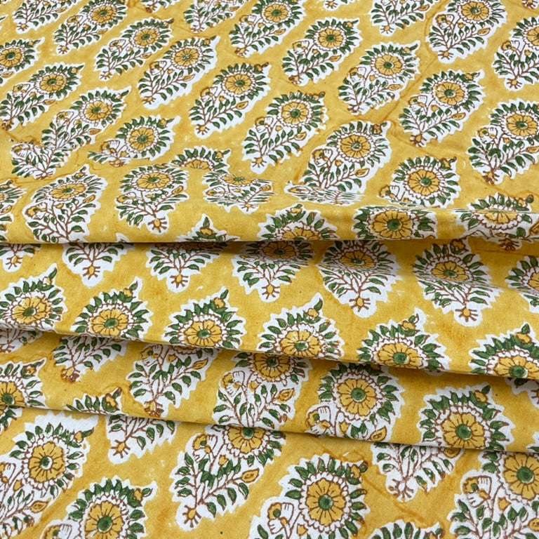 Roll of fabric with a floral pattern on a yellow background