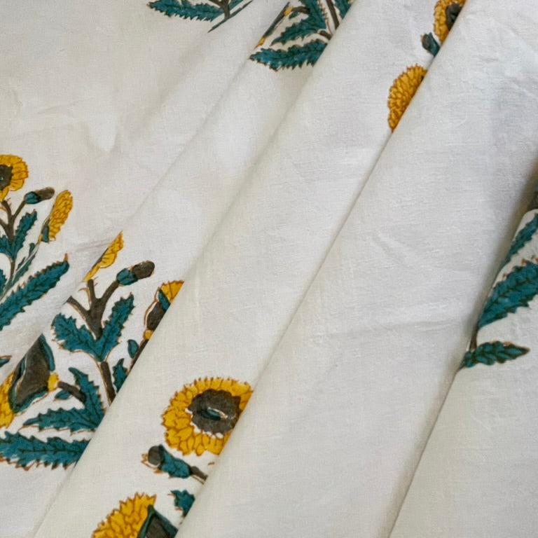 Embroidered fabric with sunflower designs on a white background