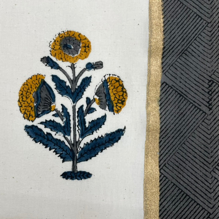 Close-up of embroidered floral design on fabric with a textured border.