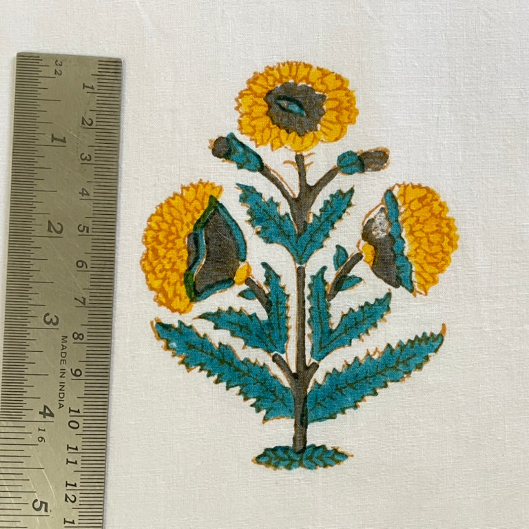 Embroidered floral design with a ruler for scale on a white background