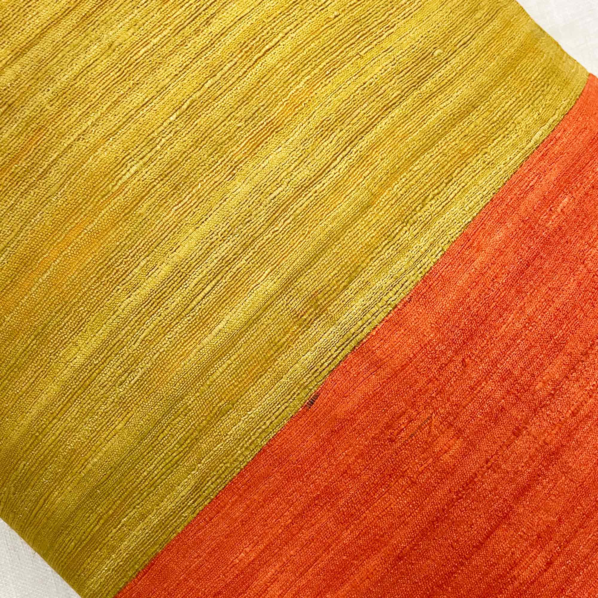 Close up of tussar silk pillow cover highlighting natural slubs and bold colorblock design.