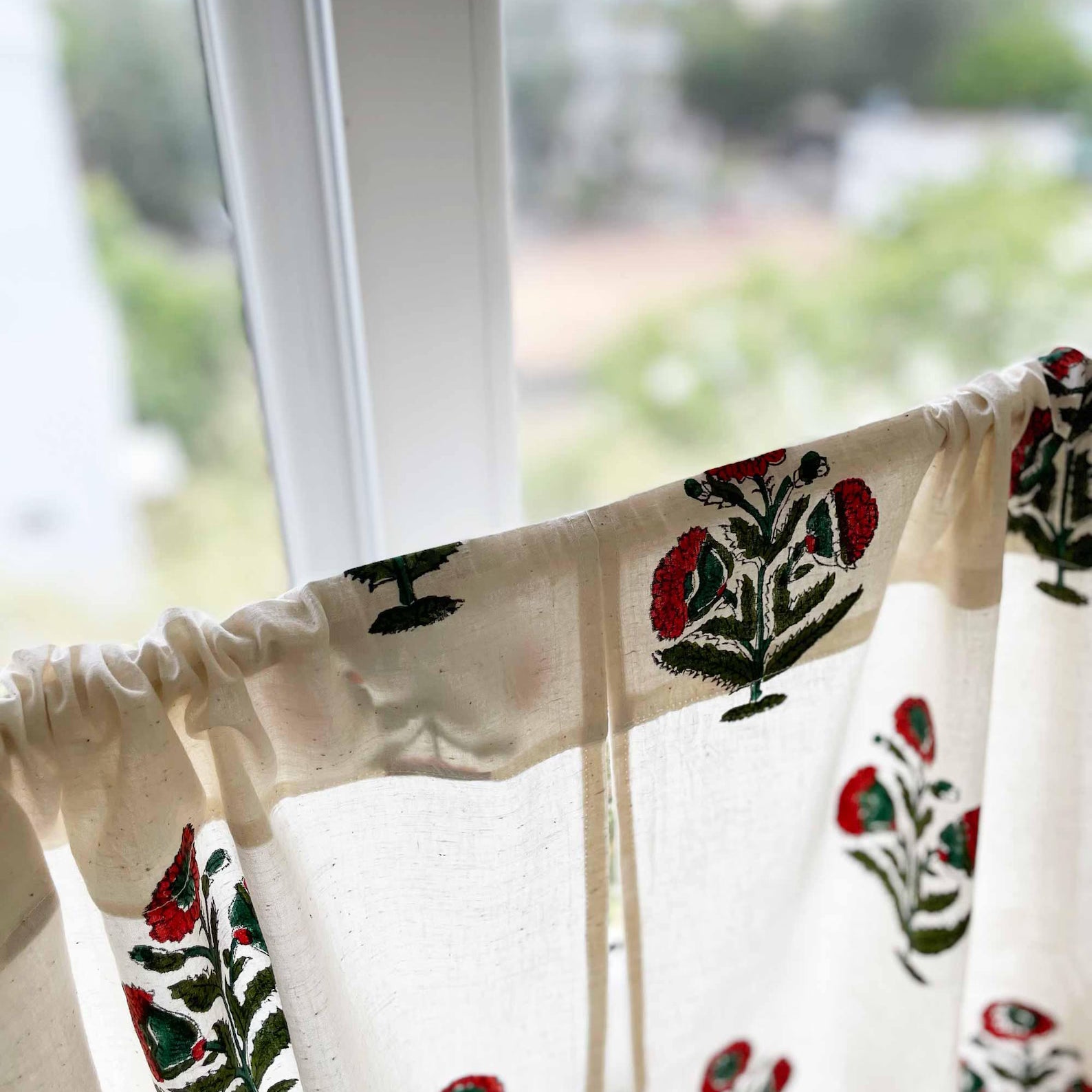 Cotton sink skirt curtain with rust and green poppy flower print, ideal for hiding storage.