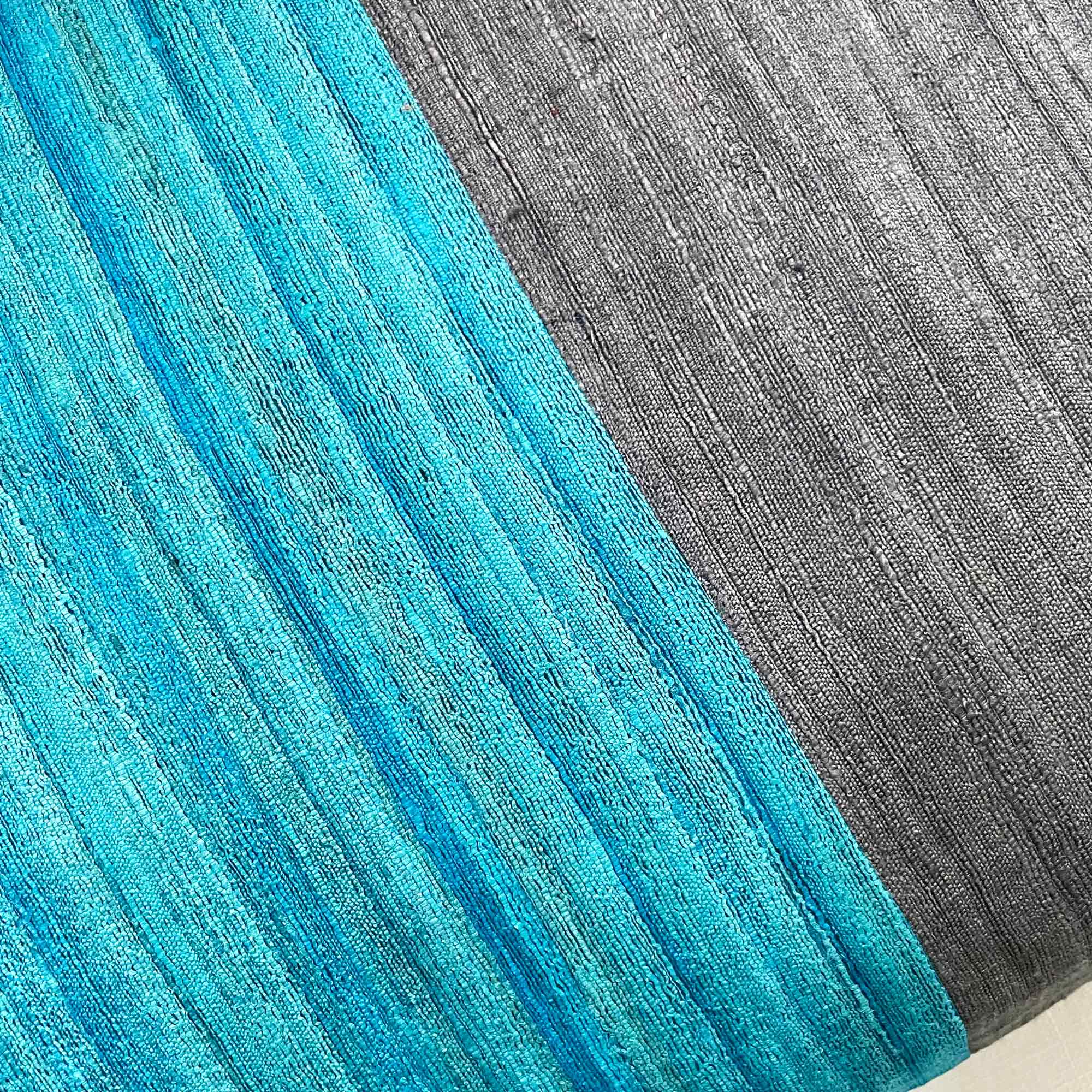 Close-up of grey and teal silk stripe pillow cover highlighting fine weave, color contrast, and silk texture.