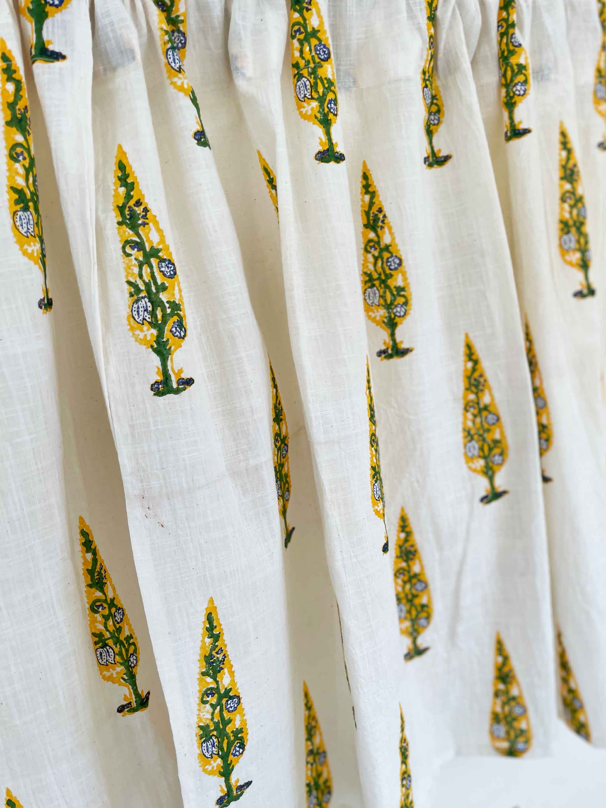 Close-up of white fabric with yellow and green floral patterns