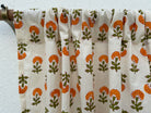 Floral patterned fabric draped over a rod against a white background
