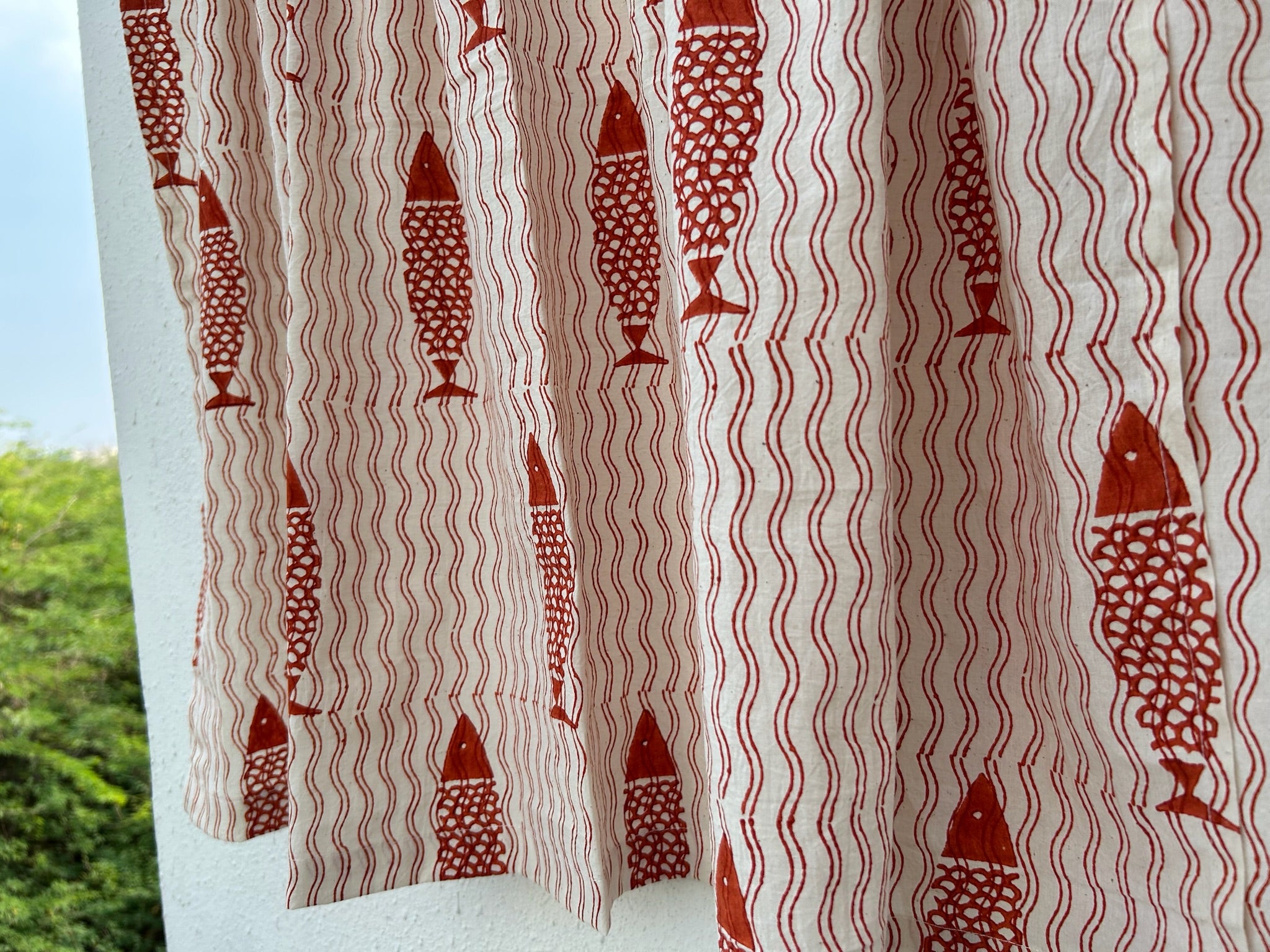 Curtain with red fish and wavy line pattern on a white background