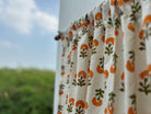 Floral-patterned fabric hanging outdoors with a blurred natural background