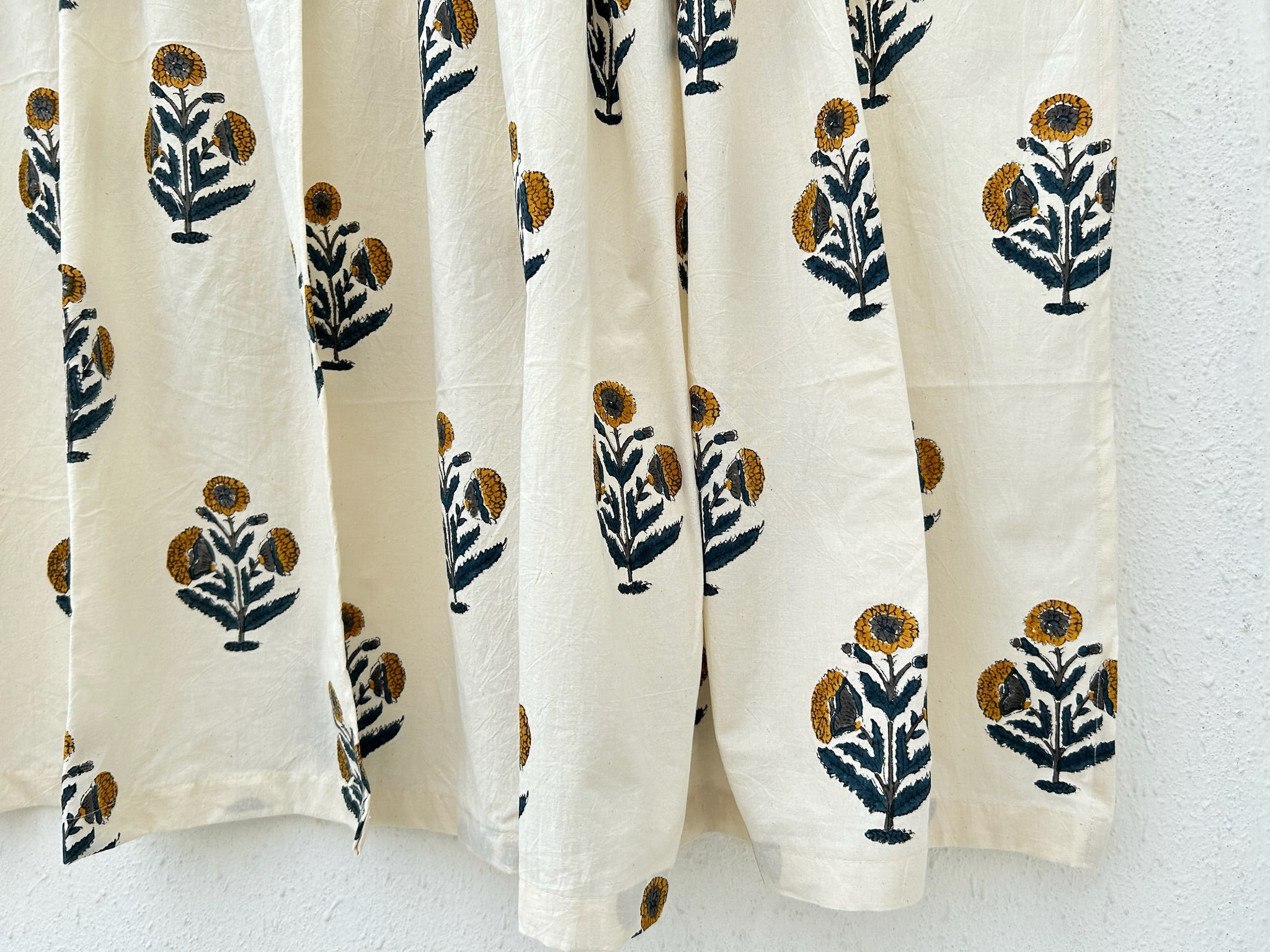 White curtains with black and gold floral patterns on a white background