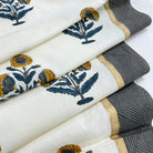Rolls of fabric with floral patterns and a textured gray fabric.