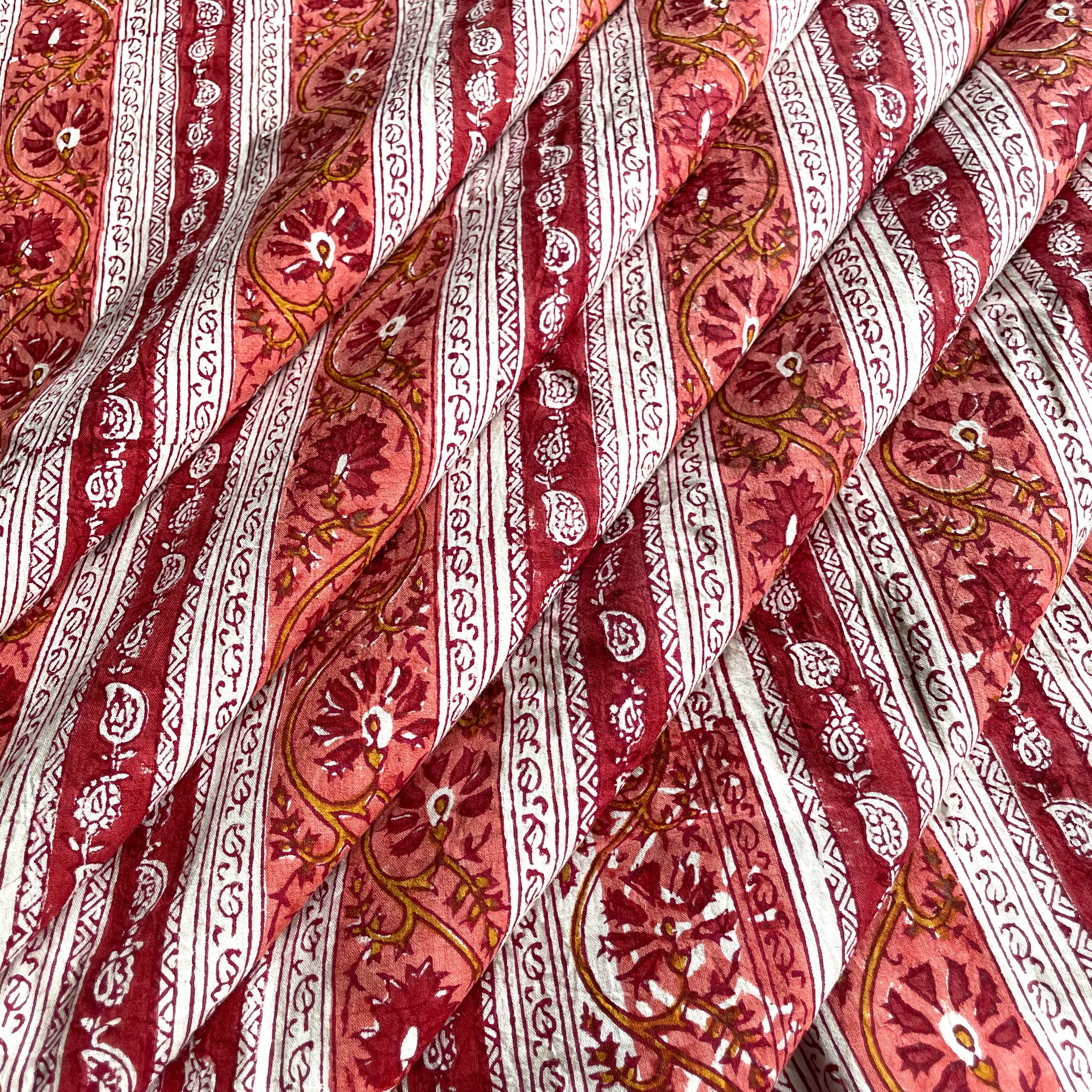 A close-up of draped fabric with a Rust and mustard color