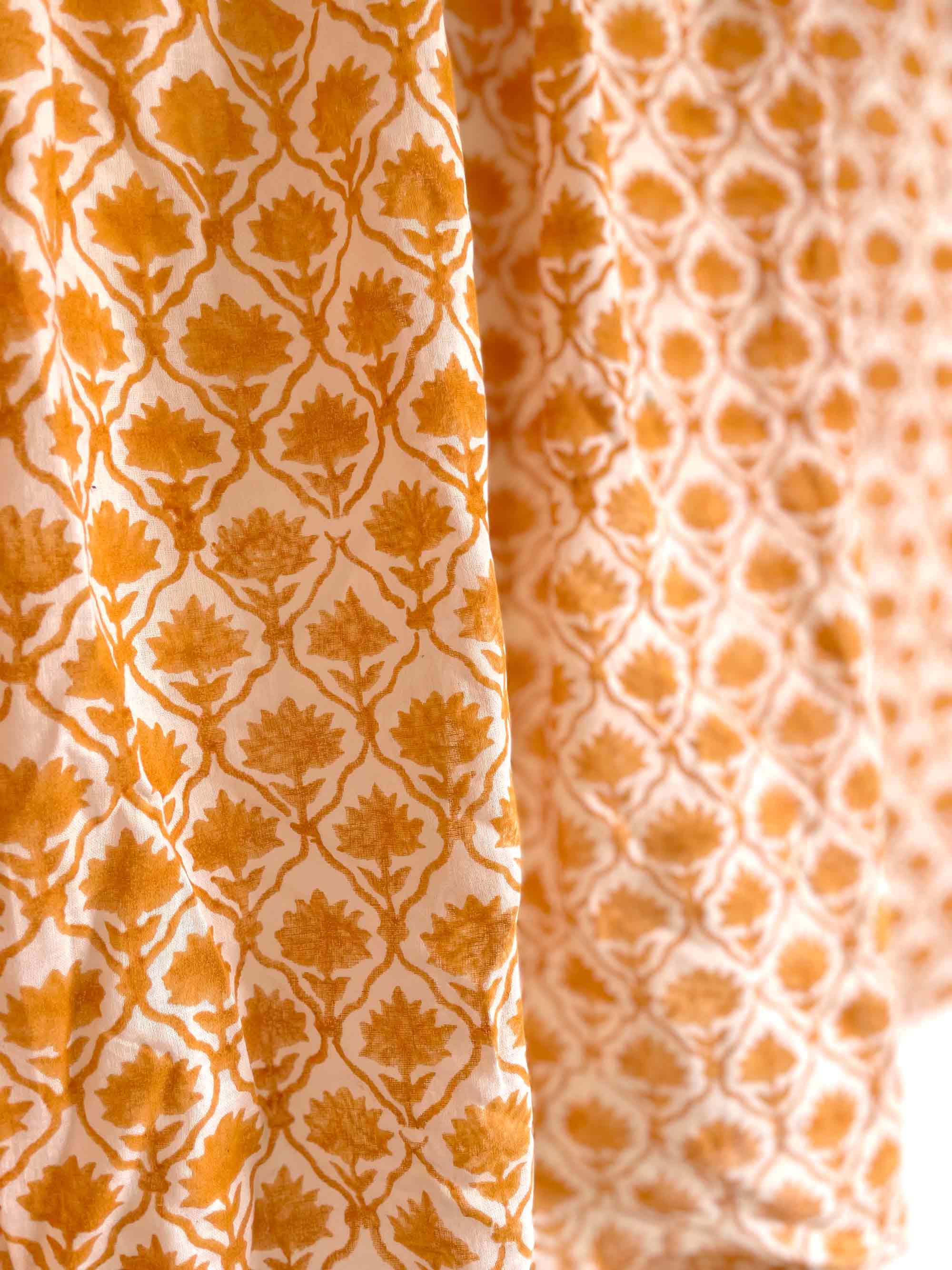 Close-up of two different patterns of orange fabric on a white background