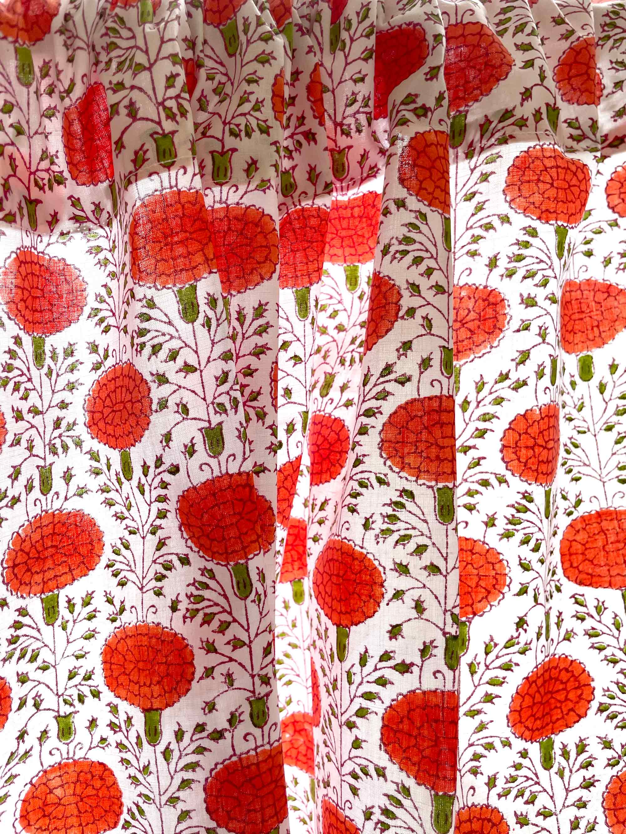 Close-up of fabric with red floral pattern on a white background