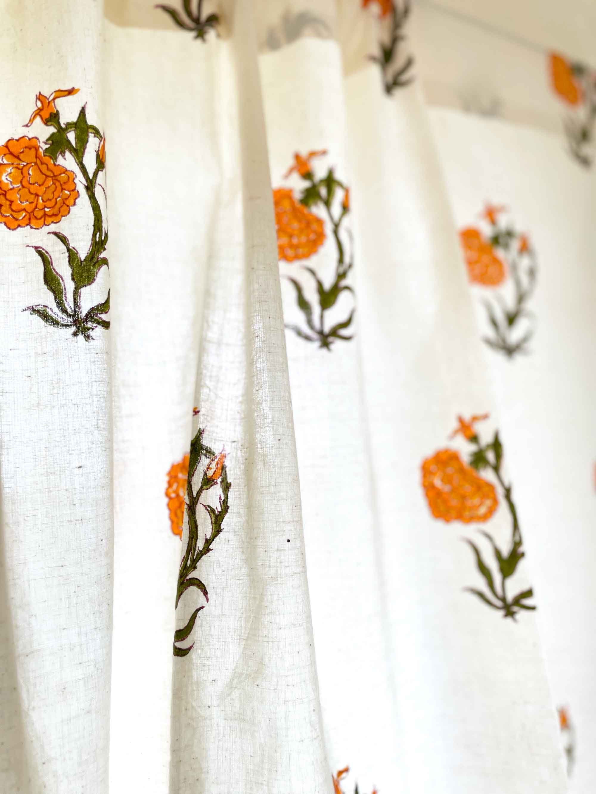 Orange marigold floral café curtain with green leaves, versatile for kitchen cupboards and sink skirts.