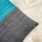Close-up of grey and teal colorblock silk pillow cover highlighting silk texture and tonal contrast.