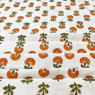 Hand block printed design in orange and green textile