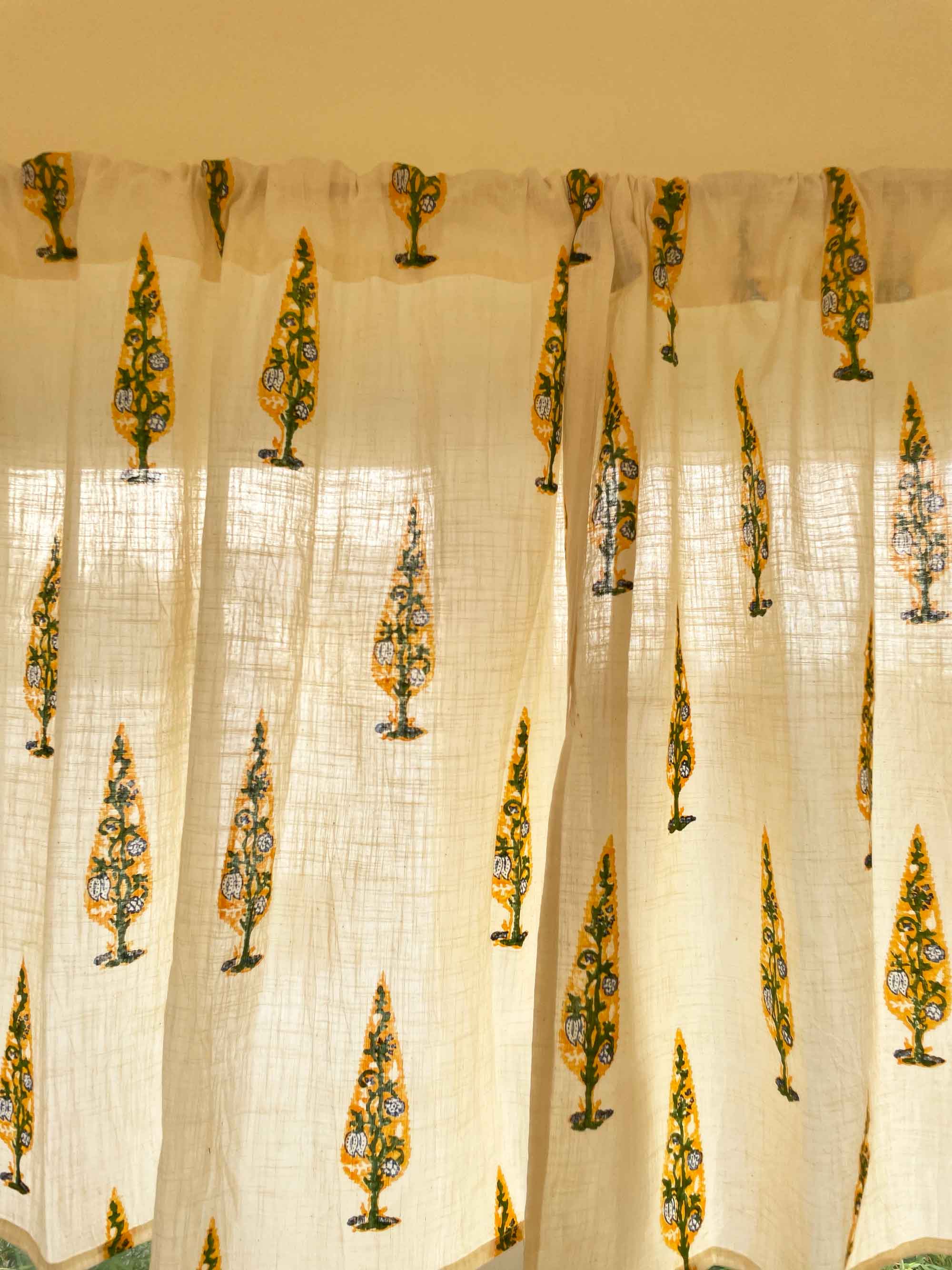 Sheer curtain with decorative yellow patterns on a white background