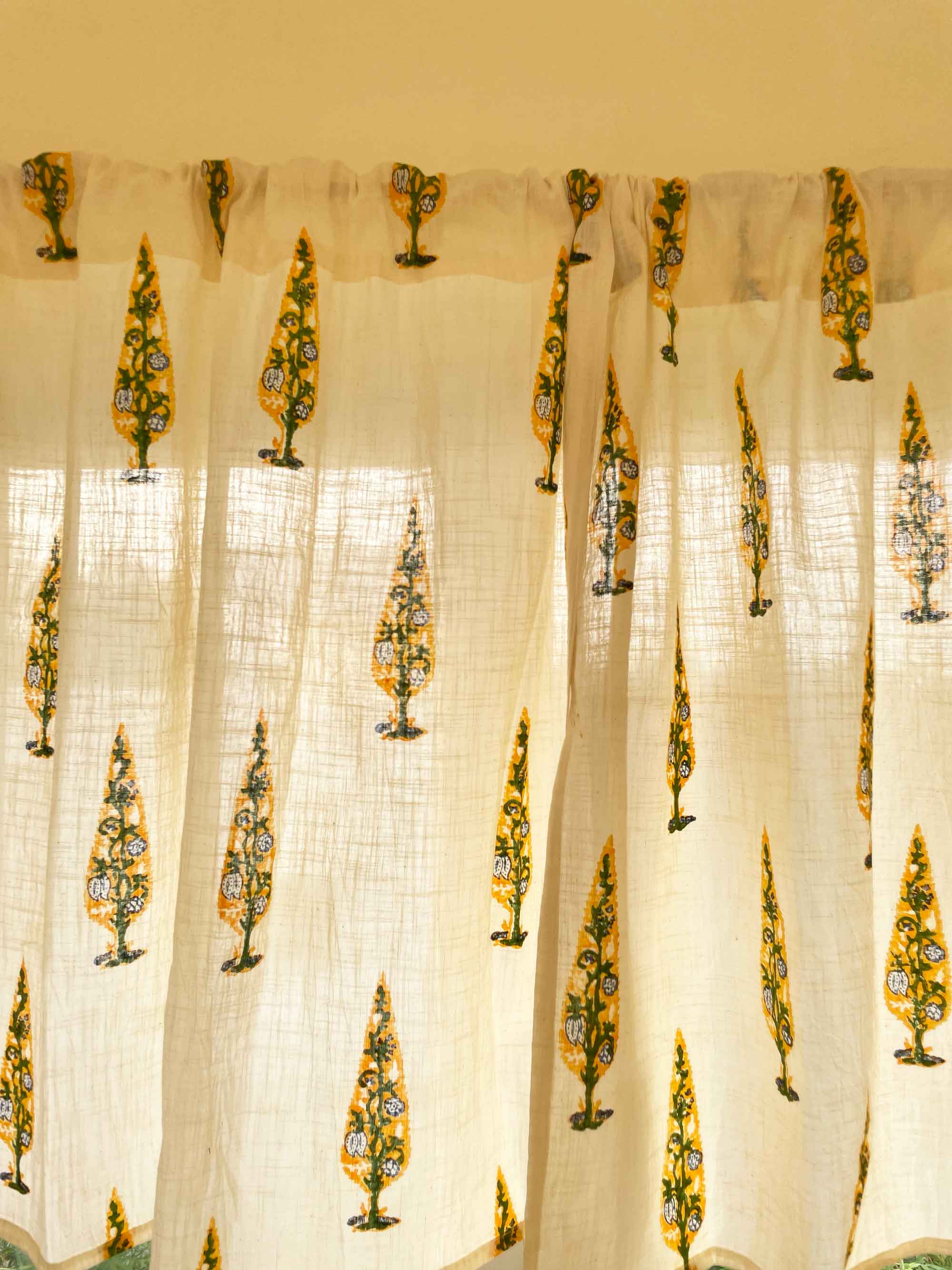 Sheer curtain with decorative yellow patterns on a beige background