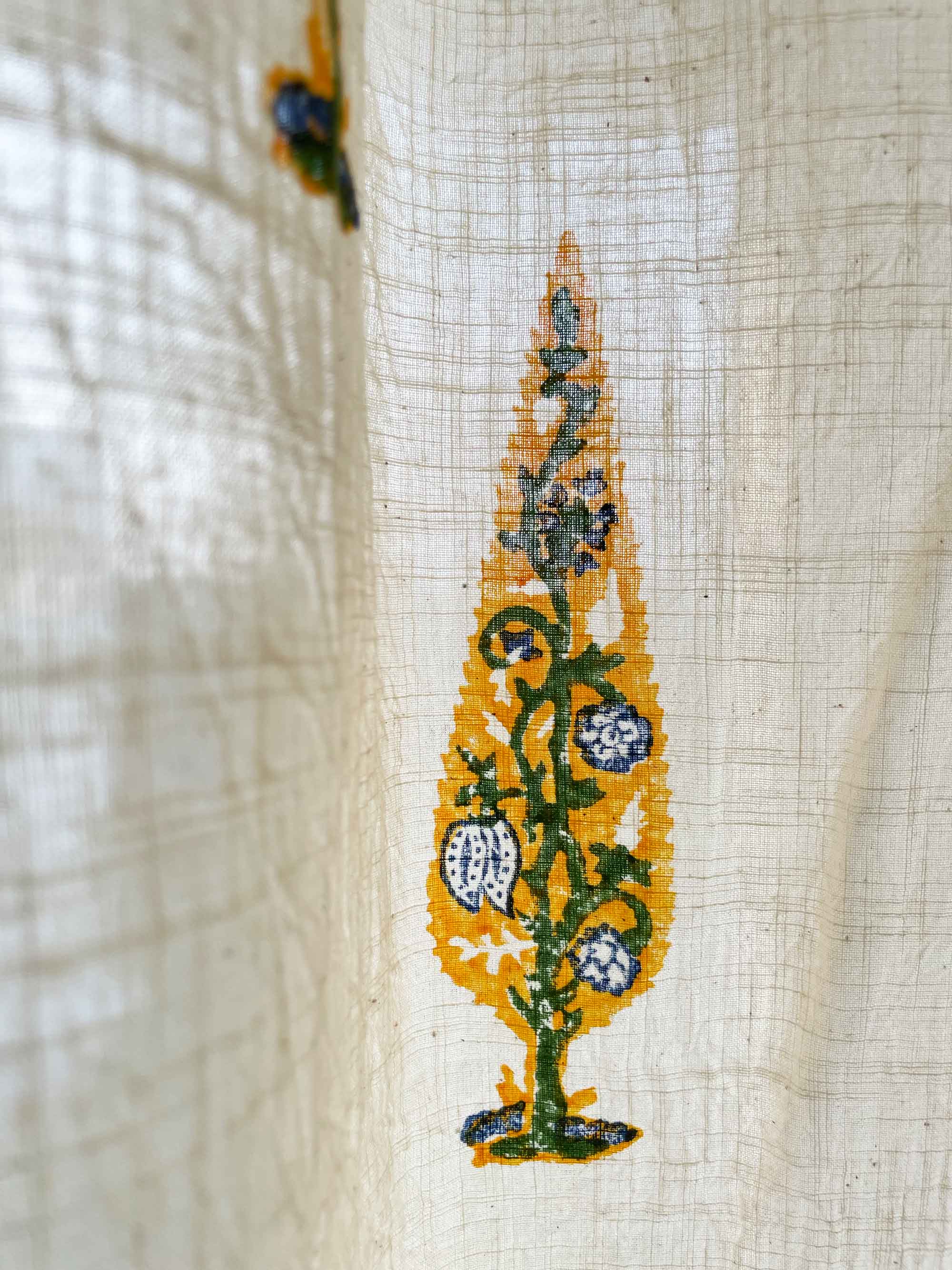 Embroidered design on fabric with yellow, green, and blue colors.